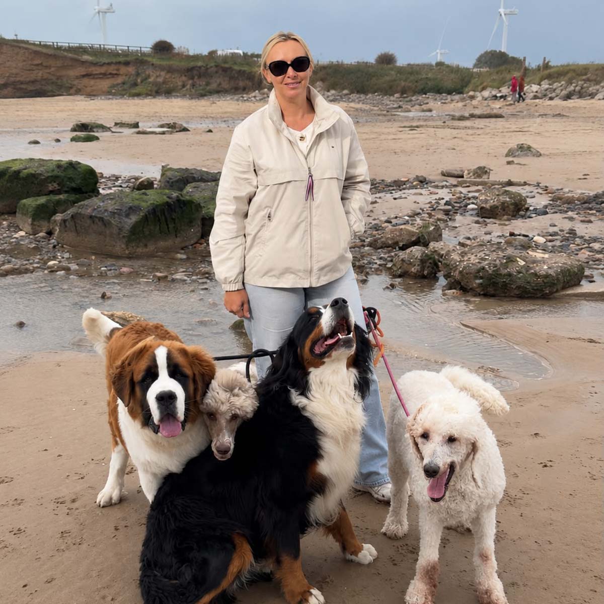 Kelly Joyner of Snoots Dog Grooming Training School Ltd with dogs on the beach